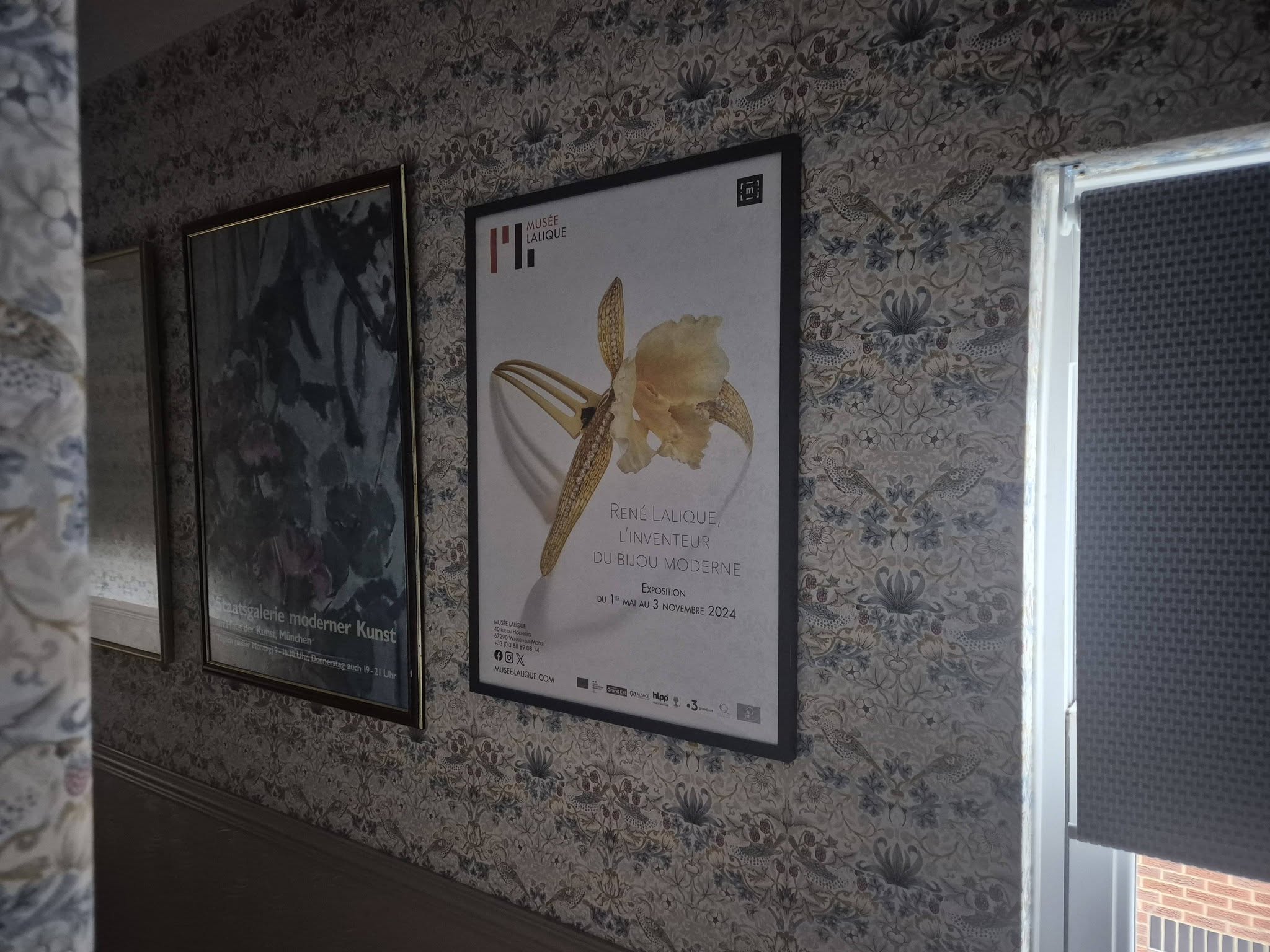Freshly wallpapered landing with a painted dado rail and framed prints