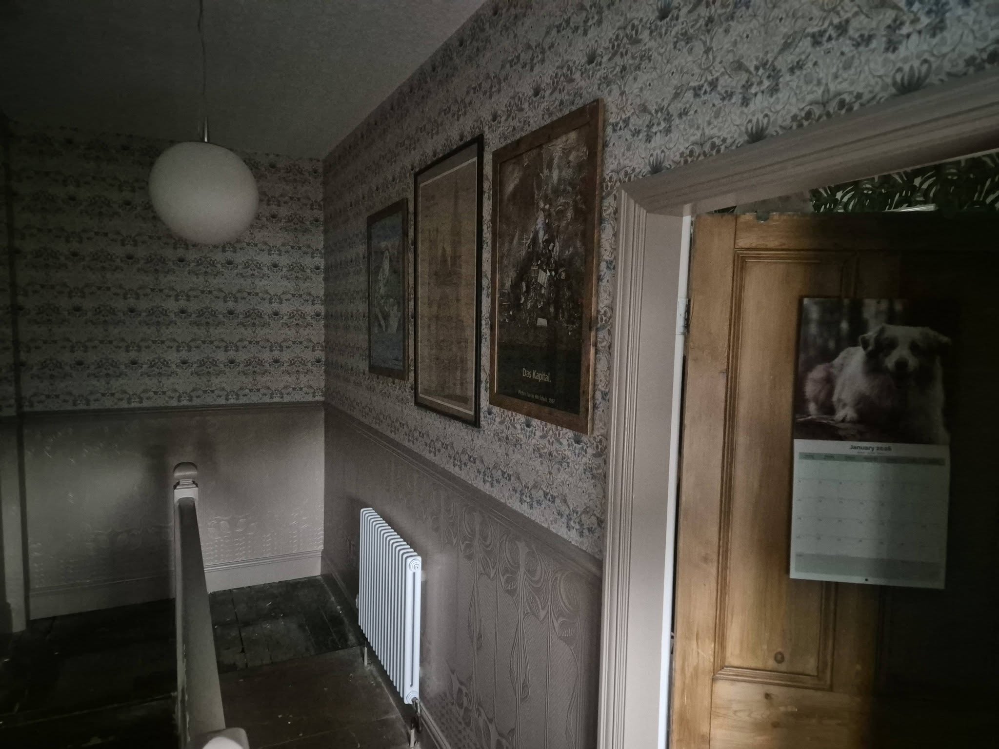 Landing with patterned wallpaper above a painted lower wall and radiator