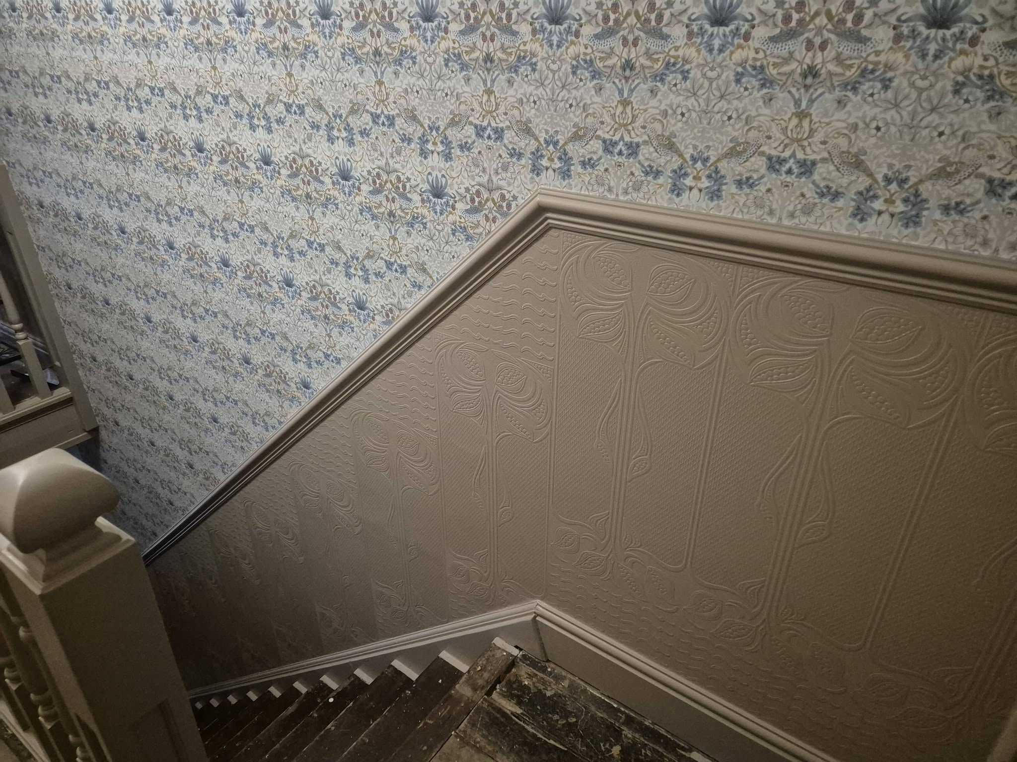 Staircase wall with new wallpaper over a painted lower wall