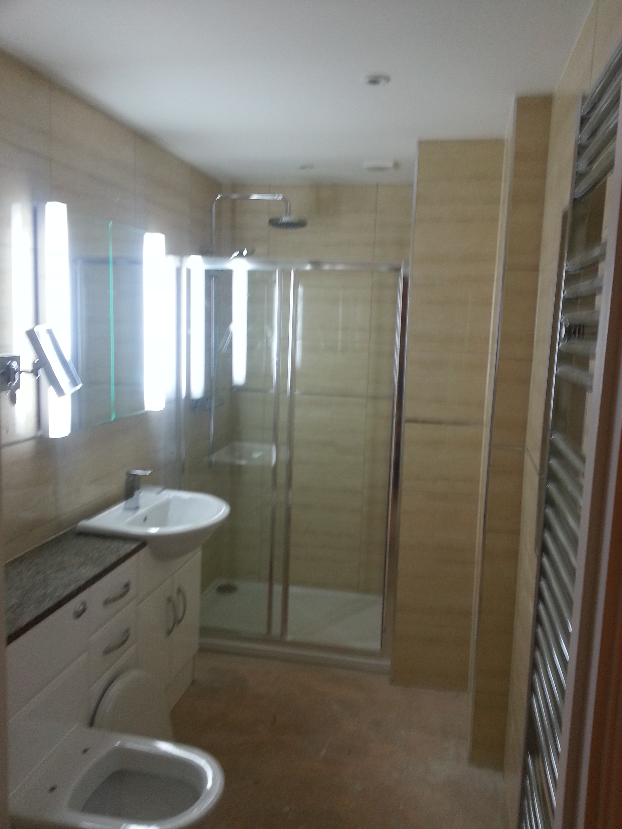 Fitted bathroom with shower enclosure, vanity unit and towel radiator